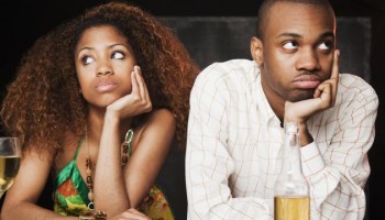 Couple sitting at bar and looking irritated