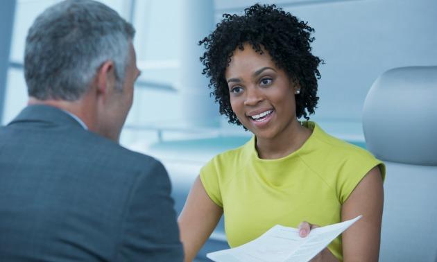 Black woman handing over resume