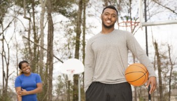 Sports: Young African descent couple play basketball at ourdoor park.