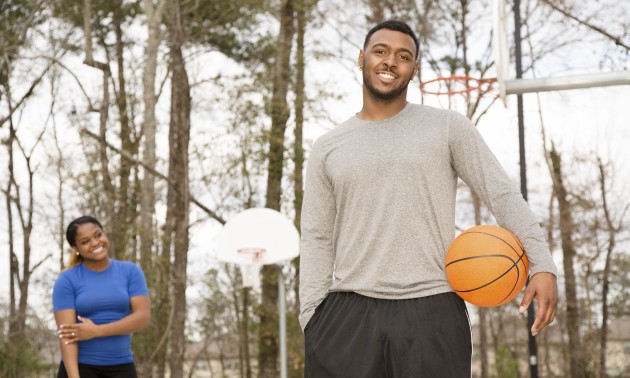 Sports: Young African descent couple play basketball at ourdoor park.