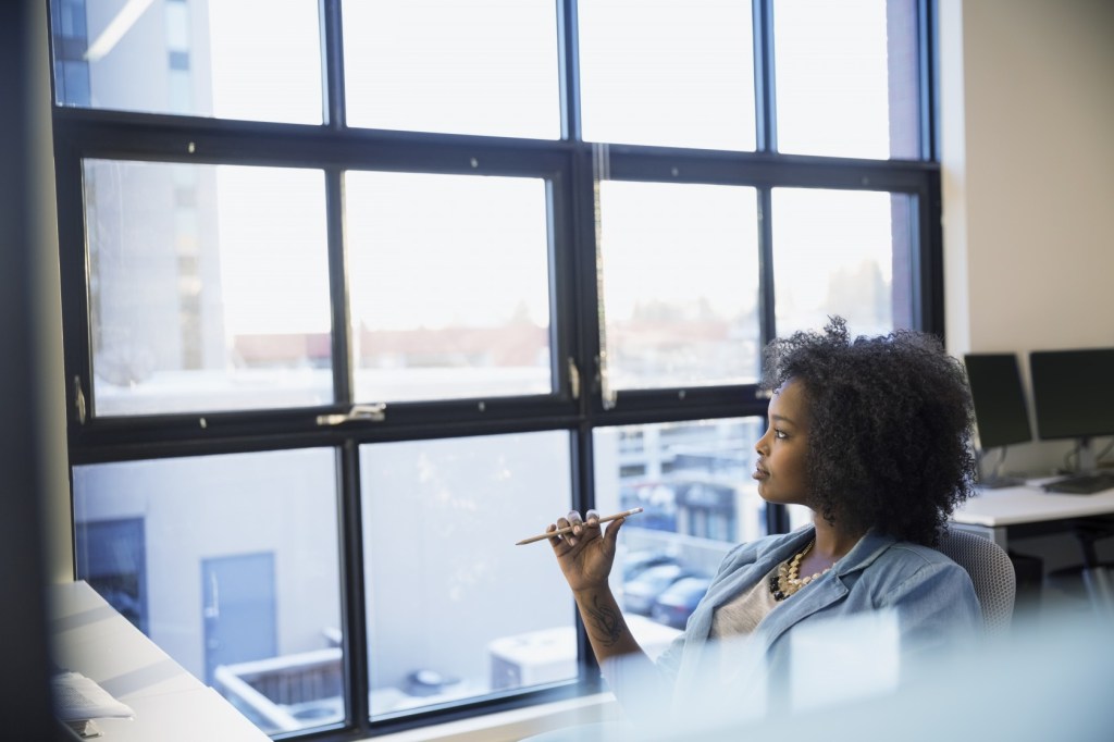 Pensive businesswoman looking out office window