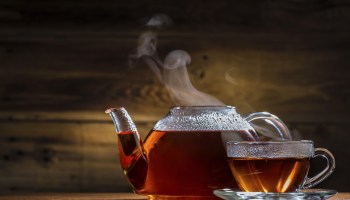 glass teapot and mug on the wooden background