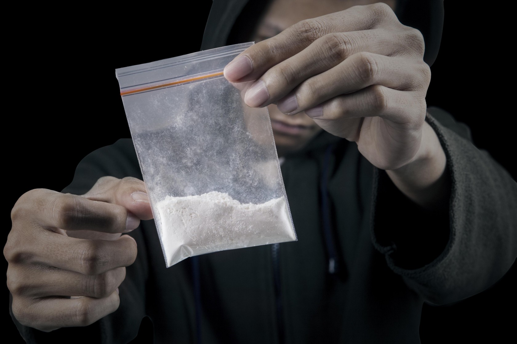 Drug dealer is preparing packet of heroin or cocaine