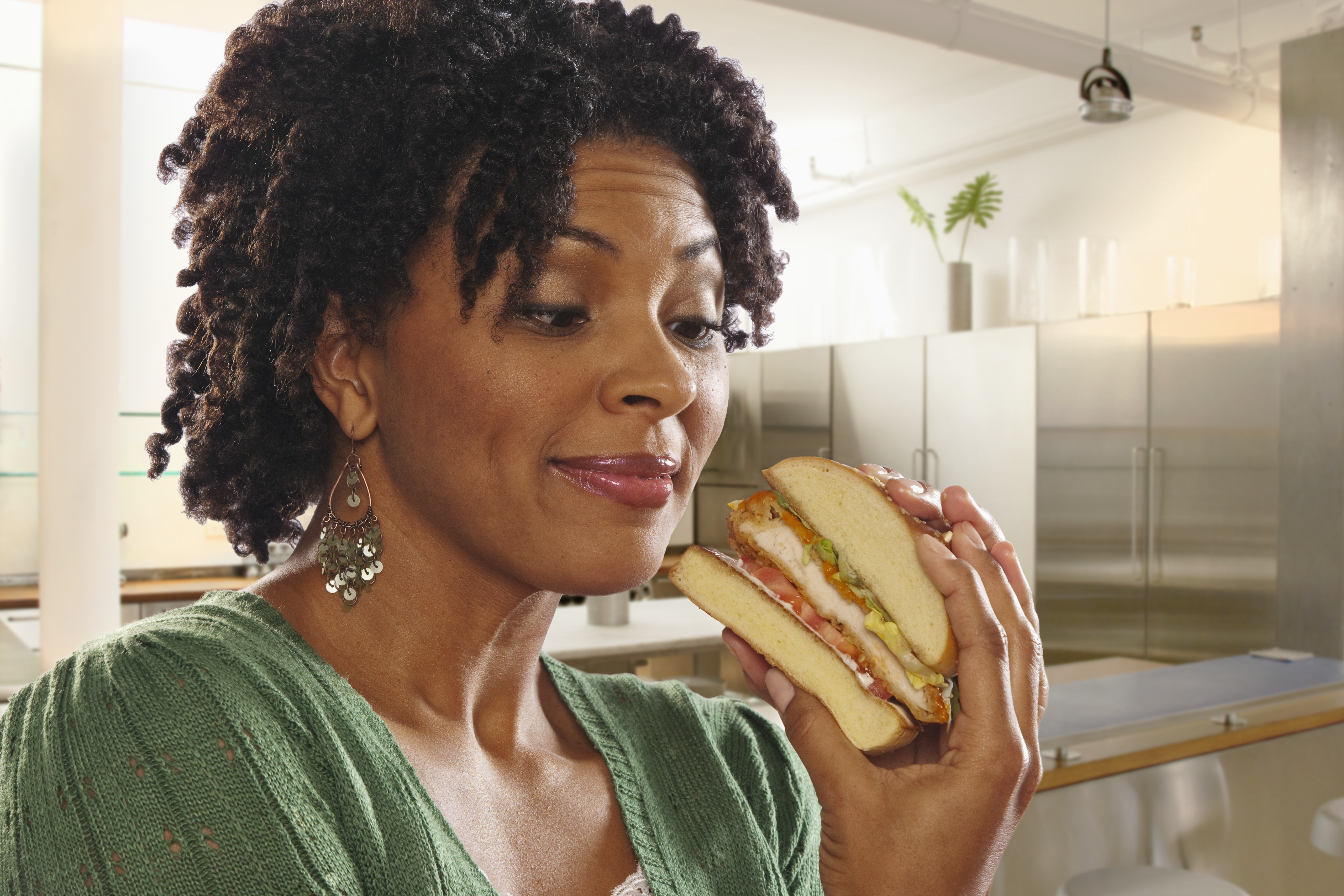 African American woman eating sandwich