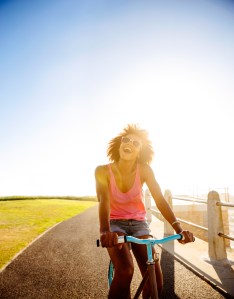 teenage girl riding her bike near beach