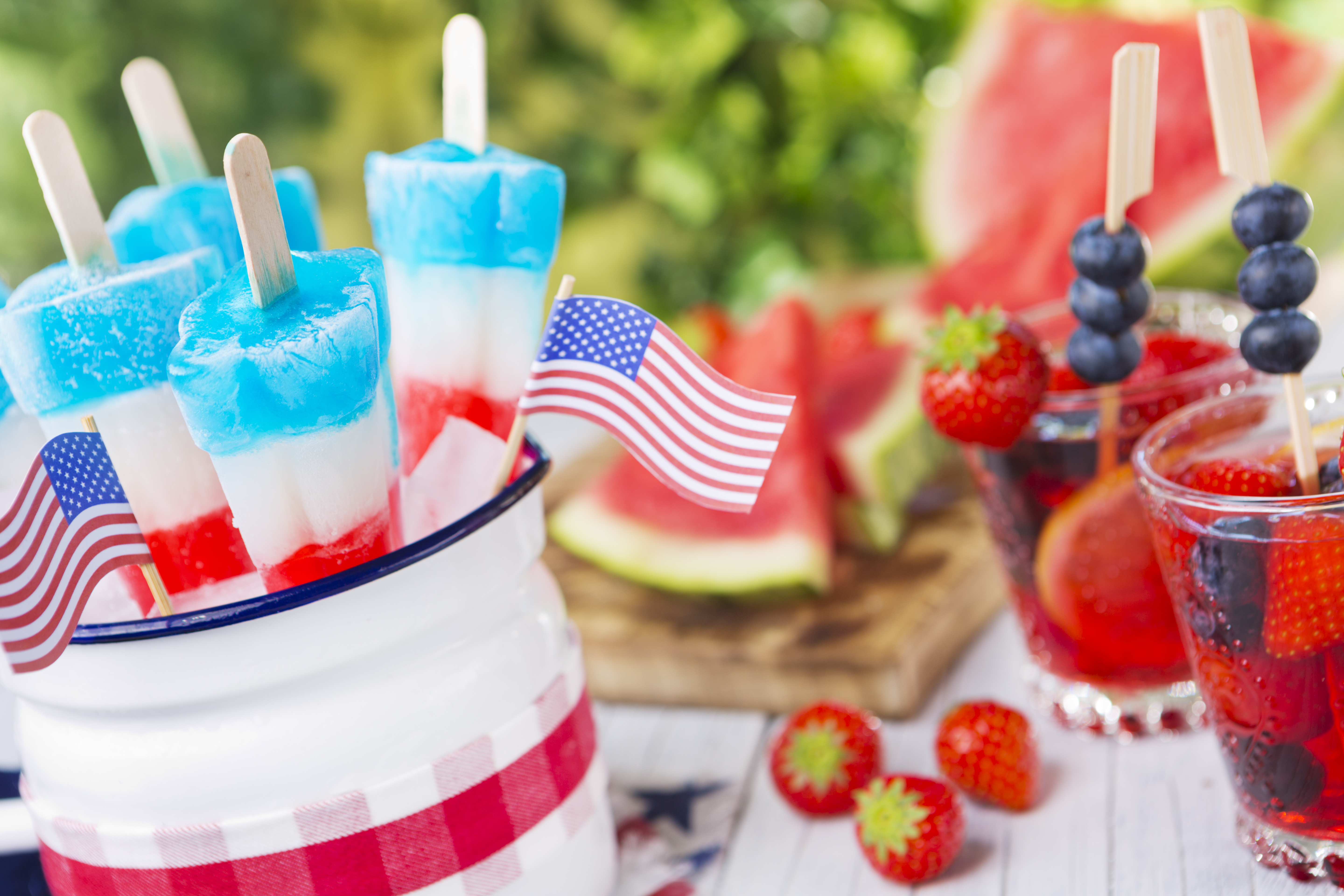 Homemade red-white-and-blue popsicles on an outdoor table.