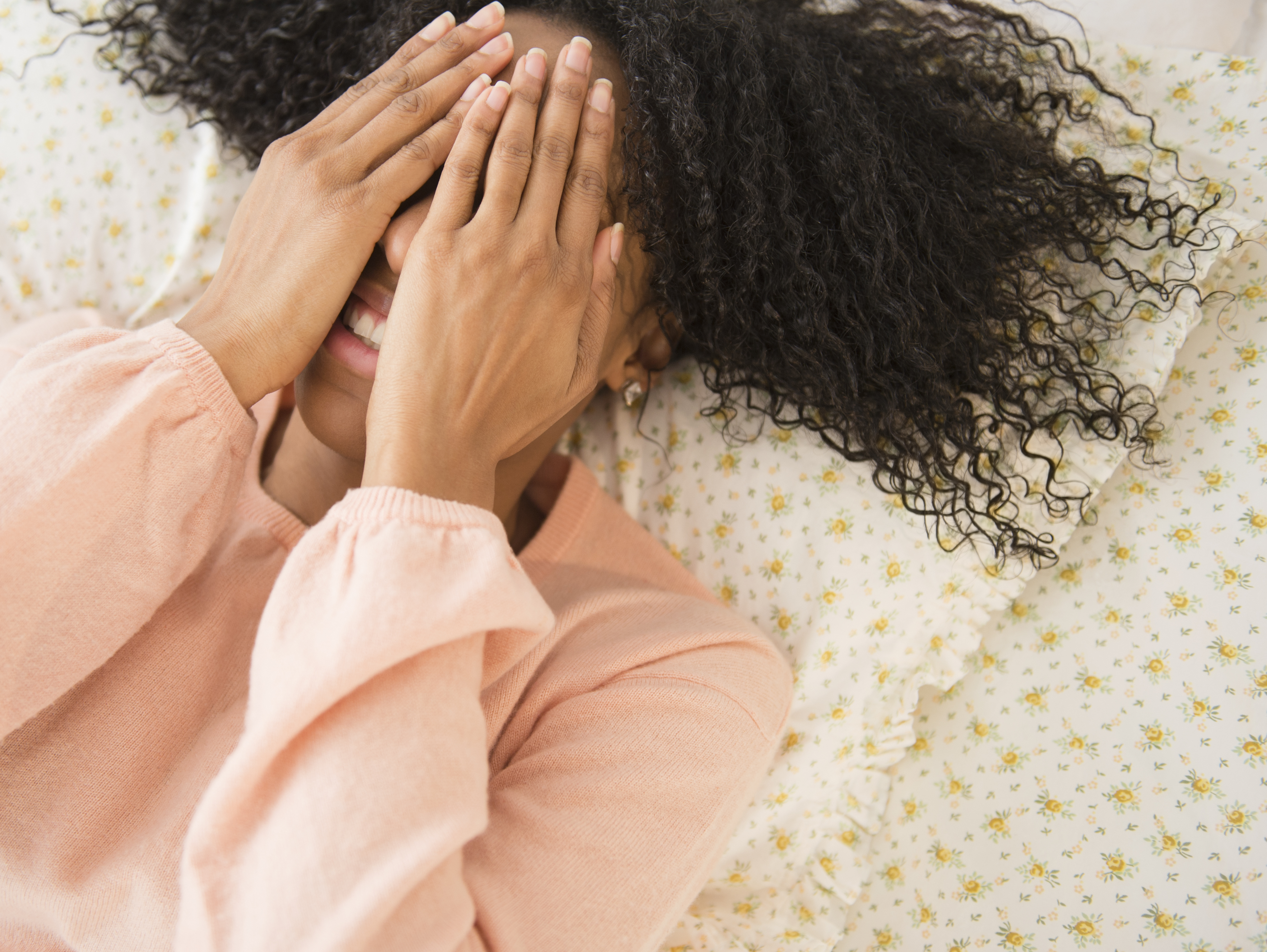 Woman laying down covering her face