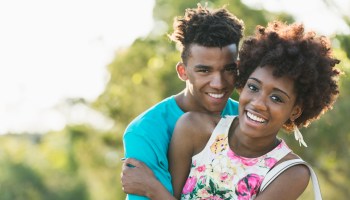 Happy young black couple on sunny summer day in park