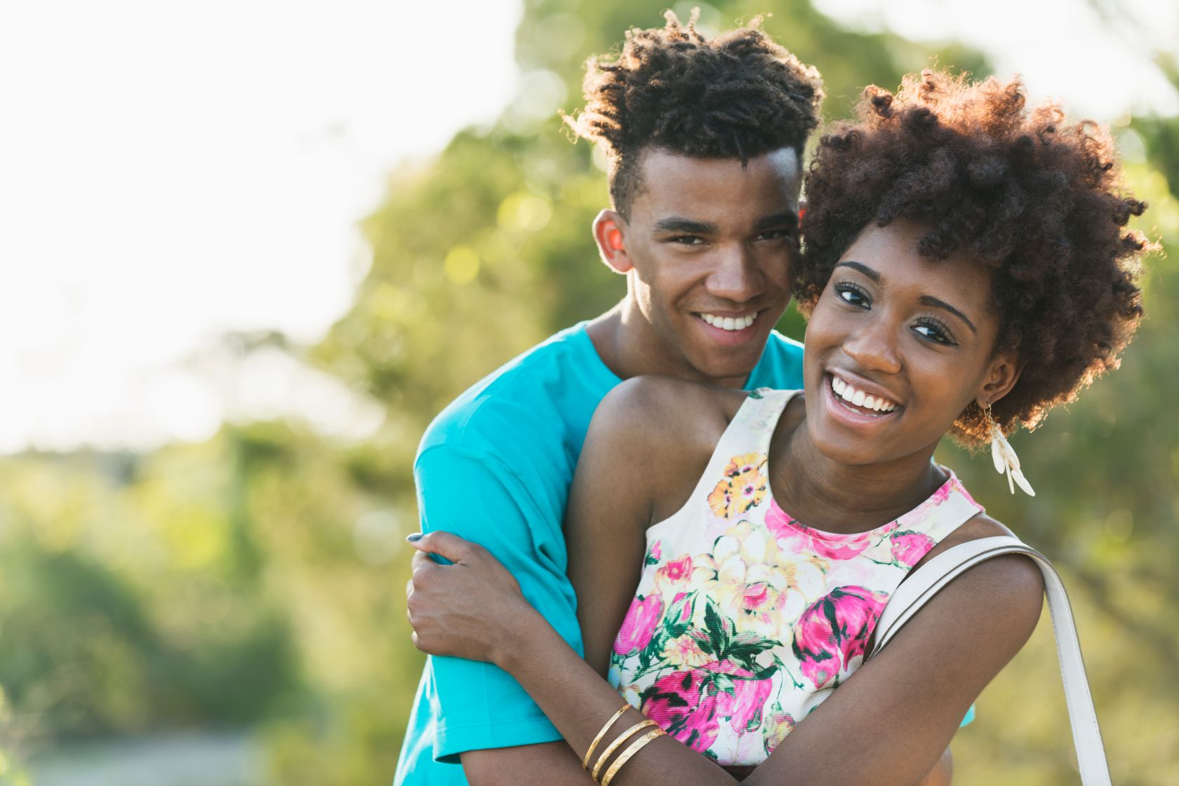 Happy young black couple on sunny summer day in park