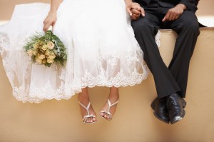 South Africa, Cape Town, Bride and groom sitting on wall