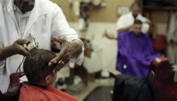 Boy getting hair cut in barber shop