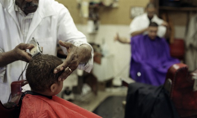 Boy getting hair cut in barber shop