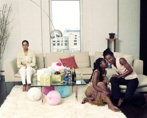 Young woman whispering to friend, third woman sitting alone