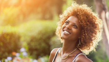 Smiling African woman in sunshine Outdoors profile portrait
