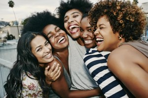 Women laughing together on urban rooftop