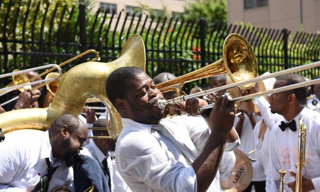 Dixieland band members play with passion along 116th Street...