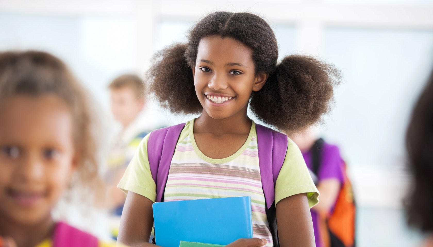 African American schoolgirl smiling and looking at camera.