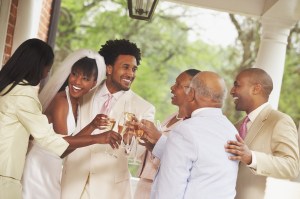 African American newlyweds toasting with family