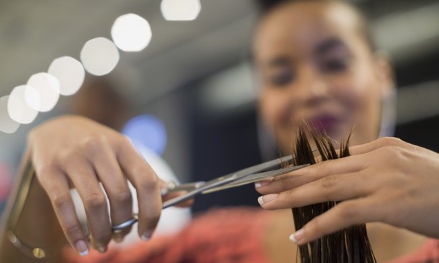 Close up hairstylist cutting hair in hair salon