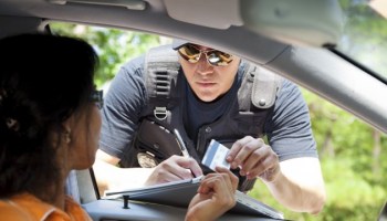 Crime: Policeman gives driver a traffic ticket.