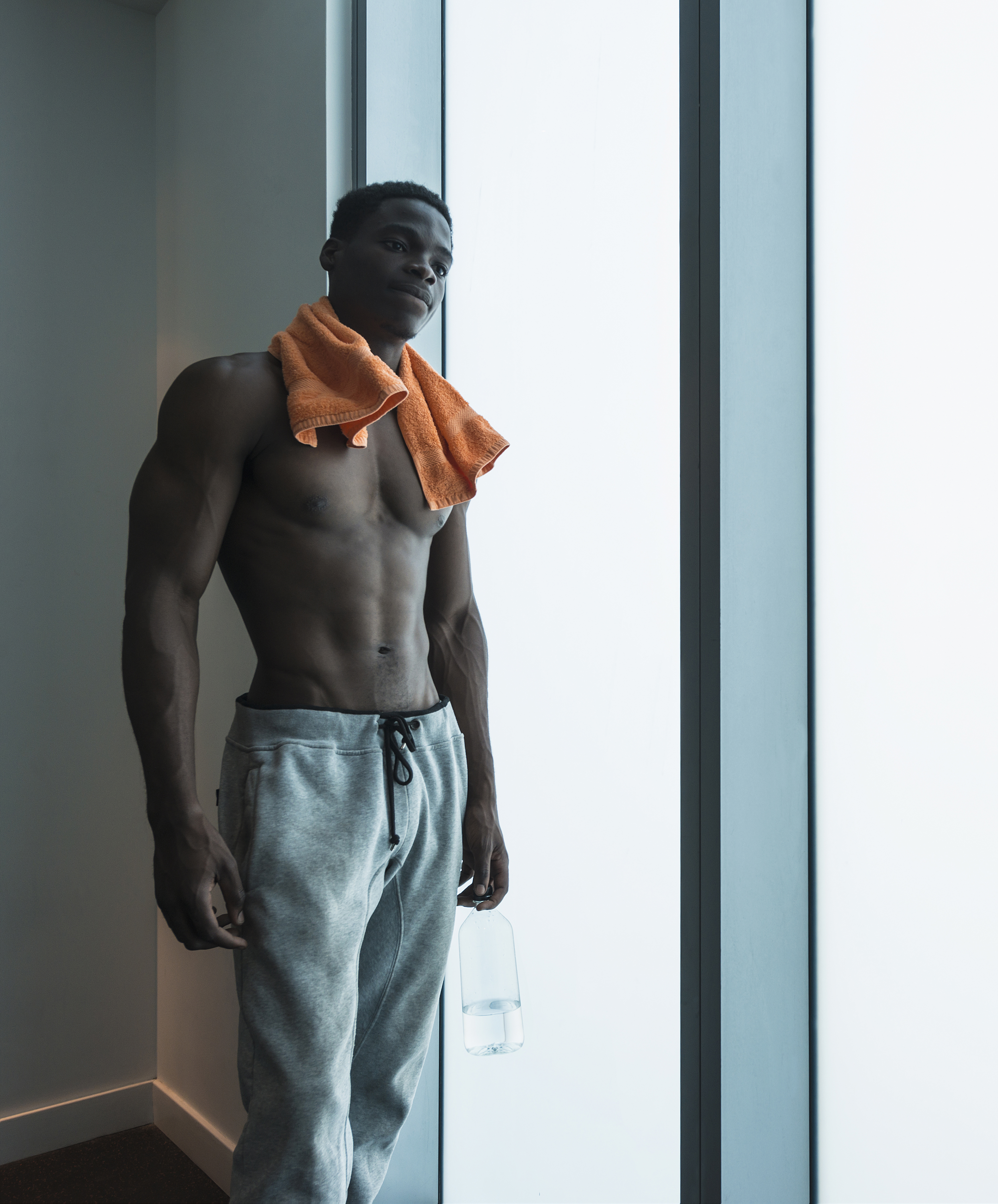African American athlete standing at window