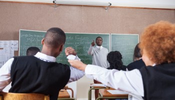 A teacher scolding students for passing notes in the classroom, Cape Town, South Africa