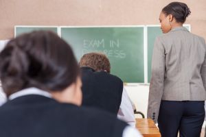 A female teacher walking around class during an exam session, Cape Town, South Africa