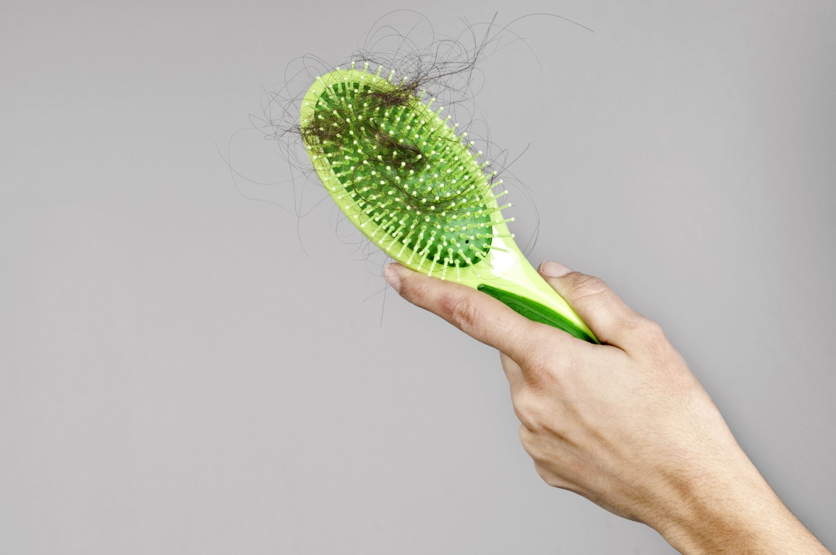 Woman losing hair on hairbrush