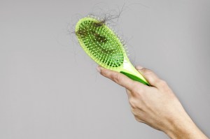 Woman losing hair on hairbrush