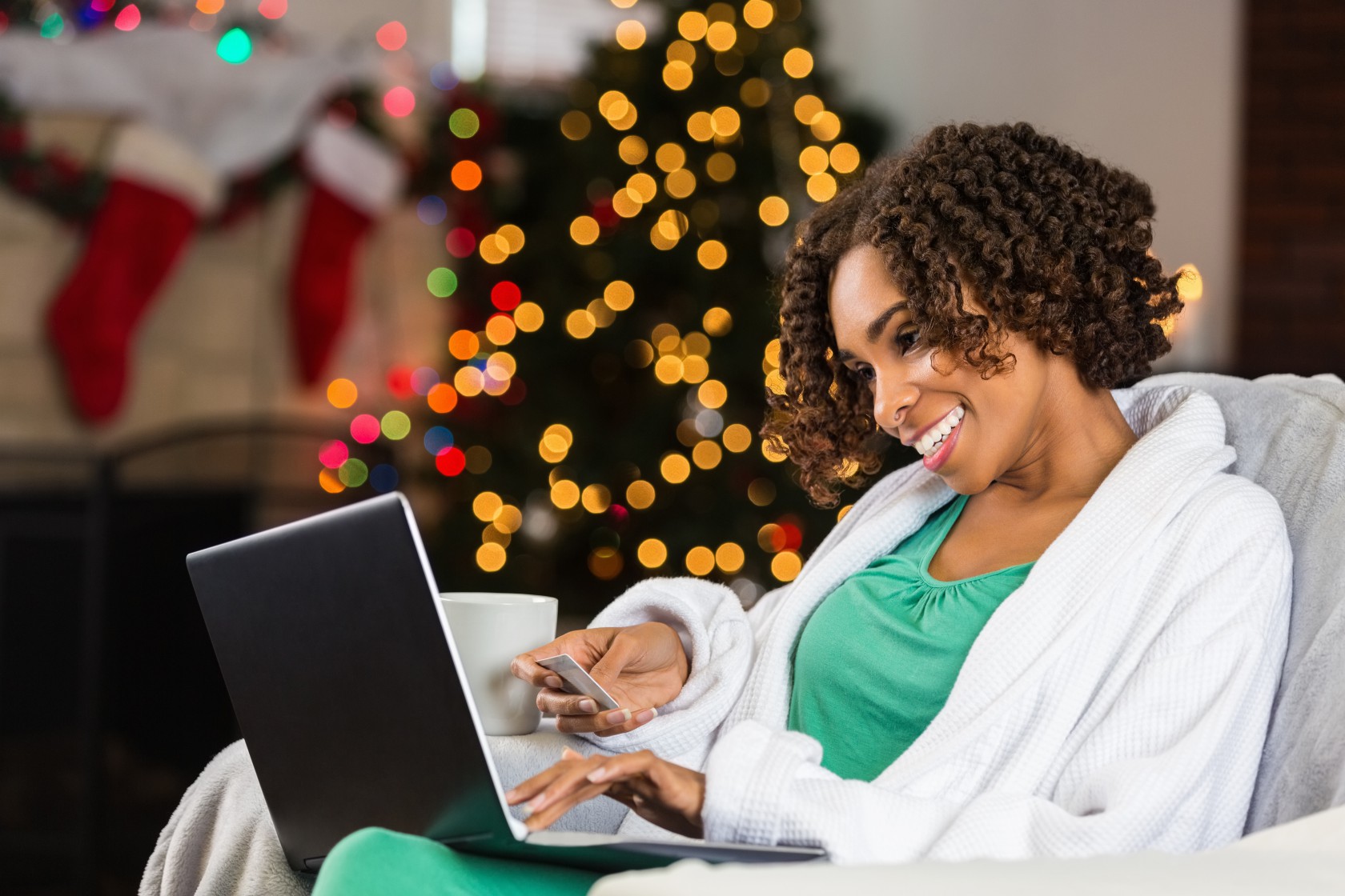 African American woman buying Christmas gifts online with credit card