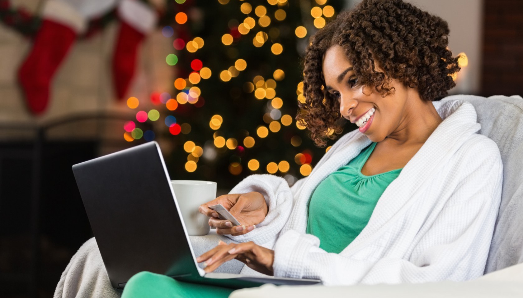 African American woman buying Christmas gifts online with credit card