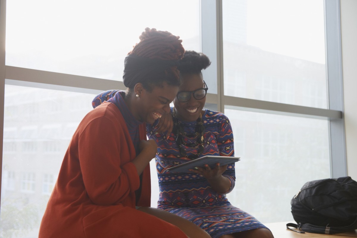 Smiling women using digital tablet