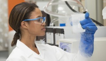 Black scientist examining liquid in laboratory