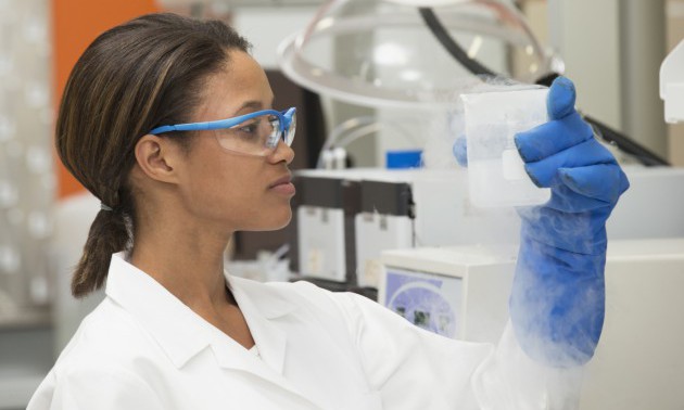 Black scientist examining liquid in laboratory