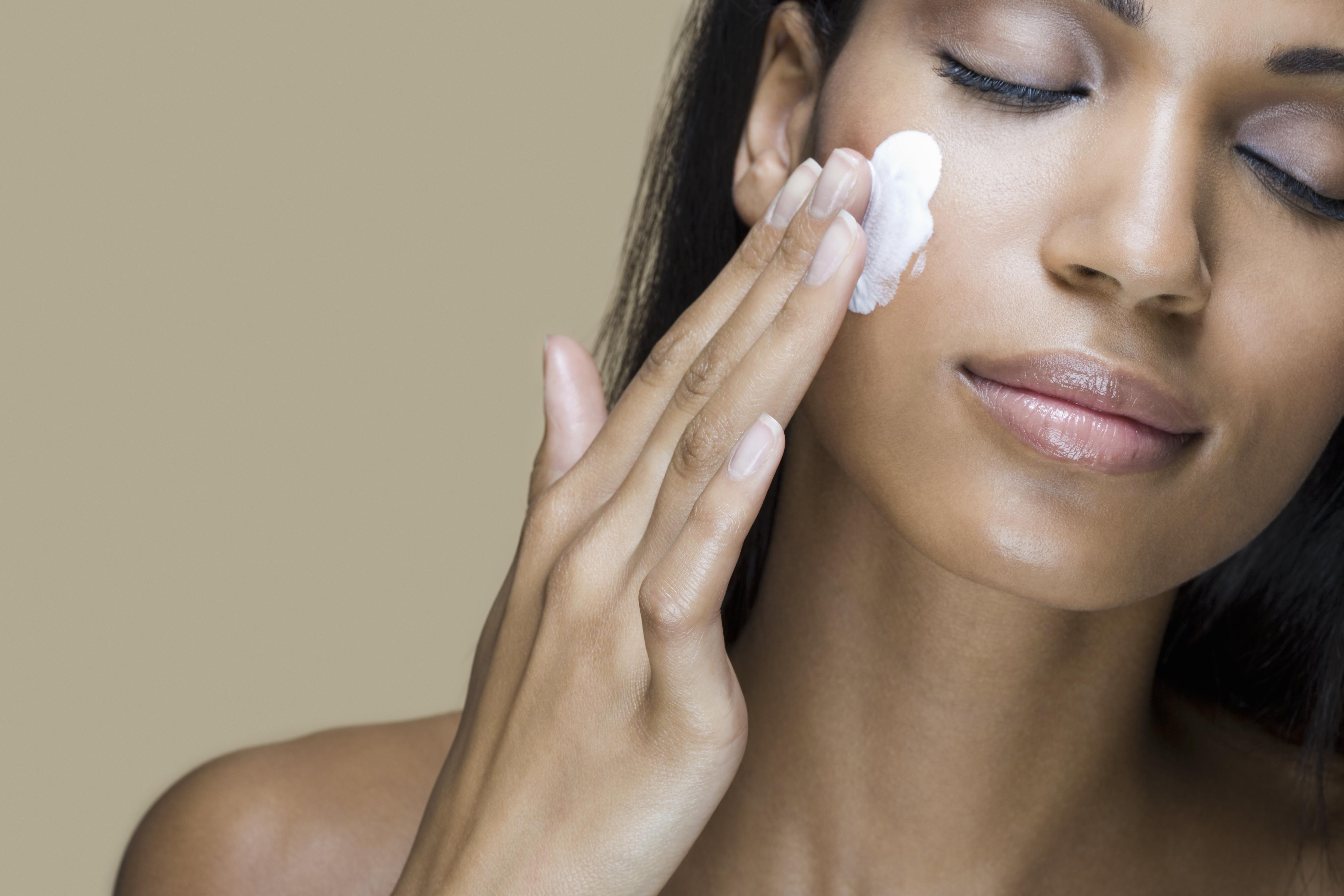 A woman rubbing moisturizer into her skin
