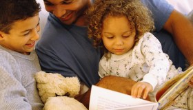 Father reading story to daughter and son