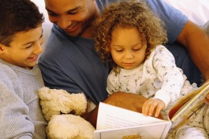 Father reading story to daughter and son