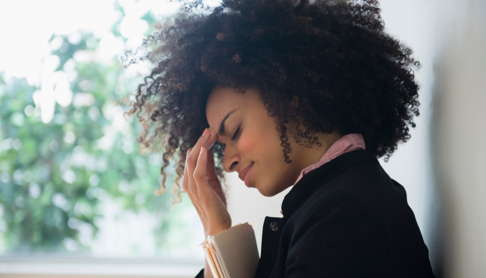 Stressed mixed race businesswoman rubbing her forehead