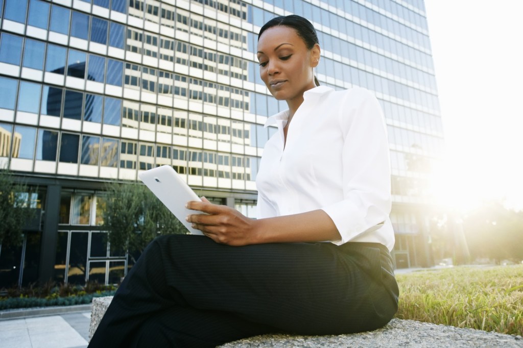 Black businesswoman using digital tablet outdoors