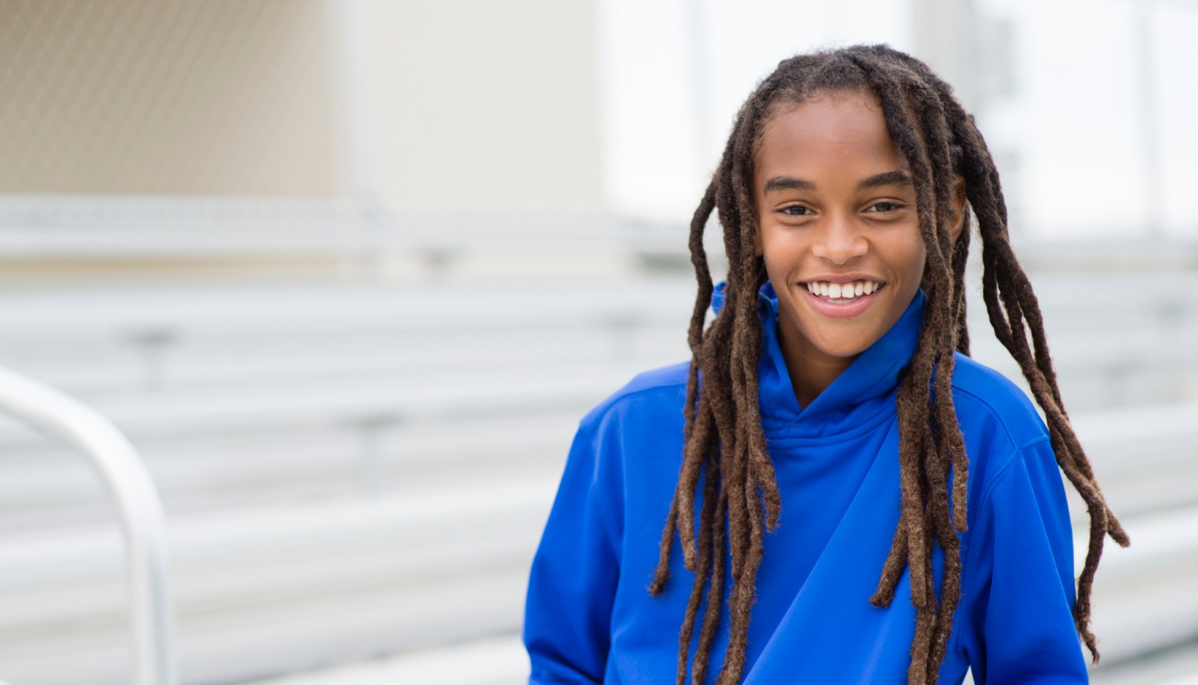 Mixed race boy smiling on bleachers