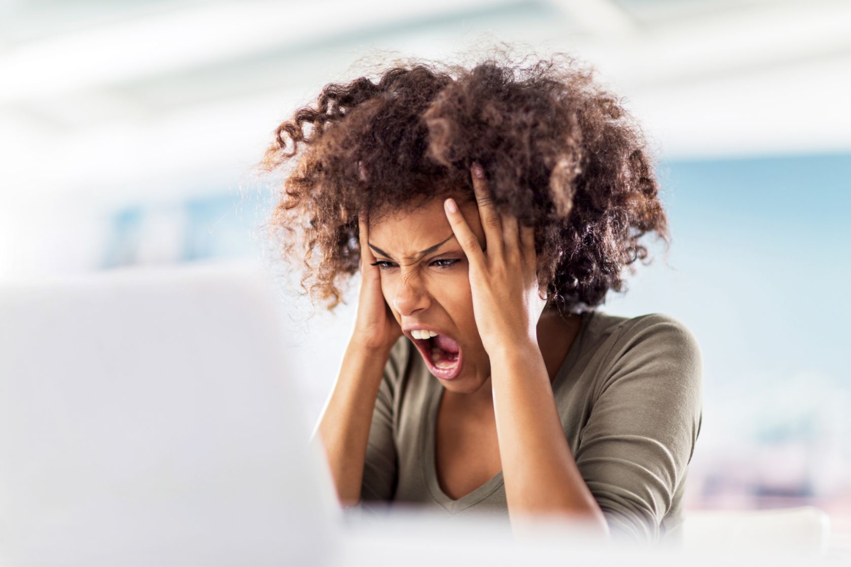 Angry African American woman using computer.