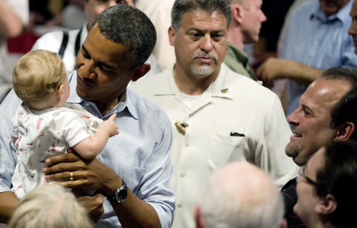 US President Barack Obama holds a baby a