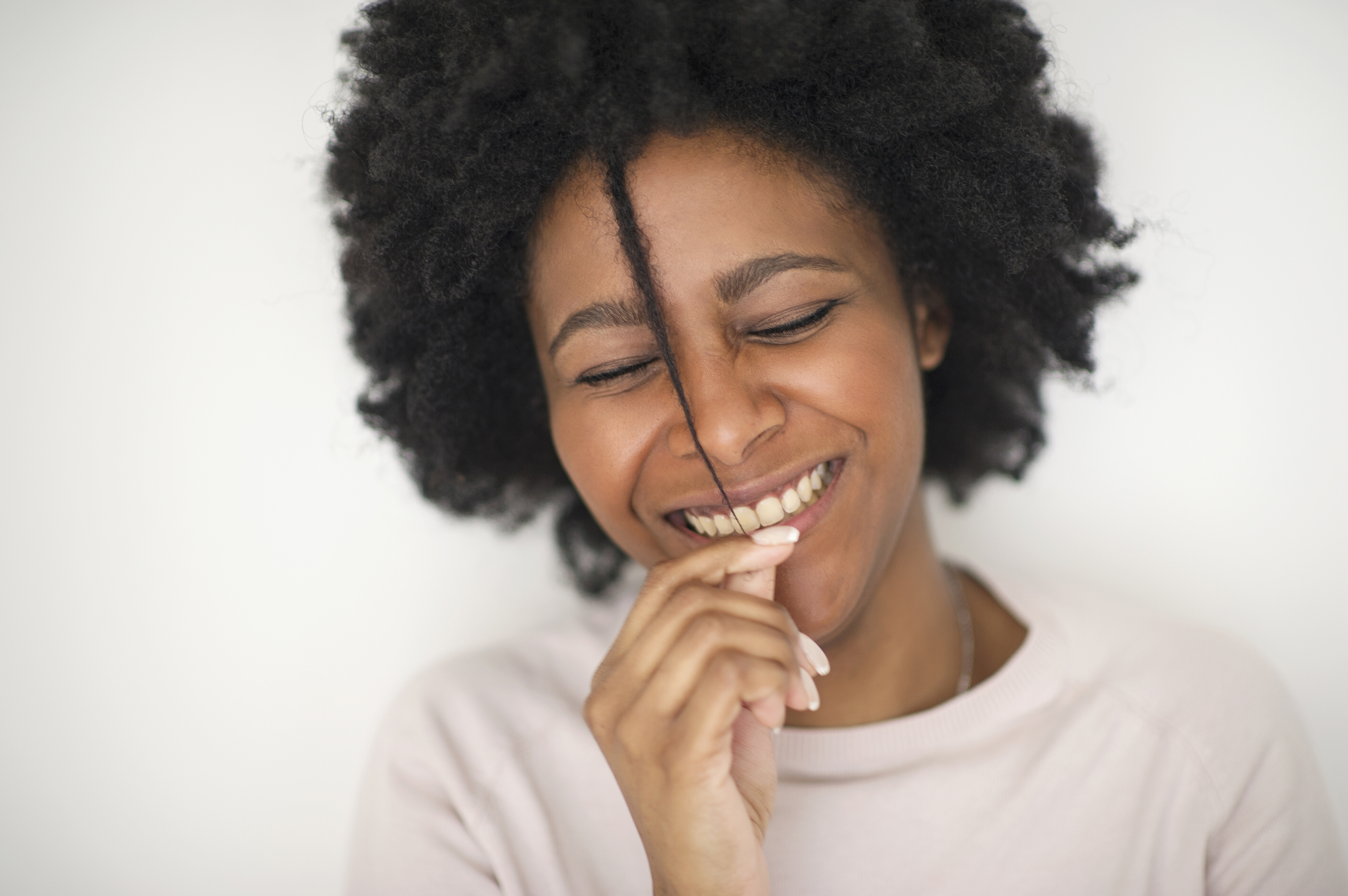 Smiling Black woman playing with hair