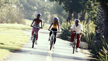 AFRICAN AMERICAN COUPLE BIKING WITH DAUGHTER