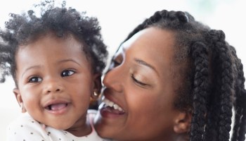 Close of smiling Black woman and baby daughter