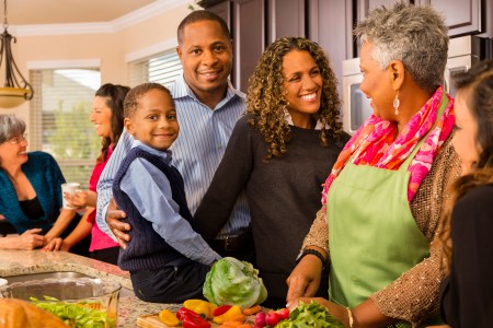 Relationships: Multi-generation family prepares dinner in kitchen.
