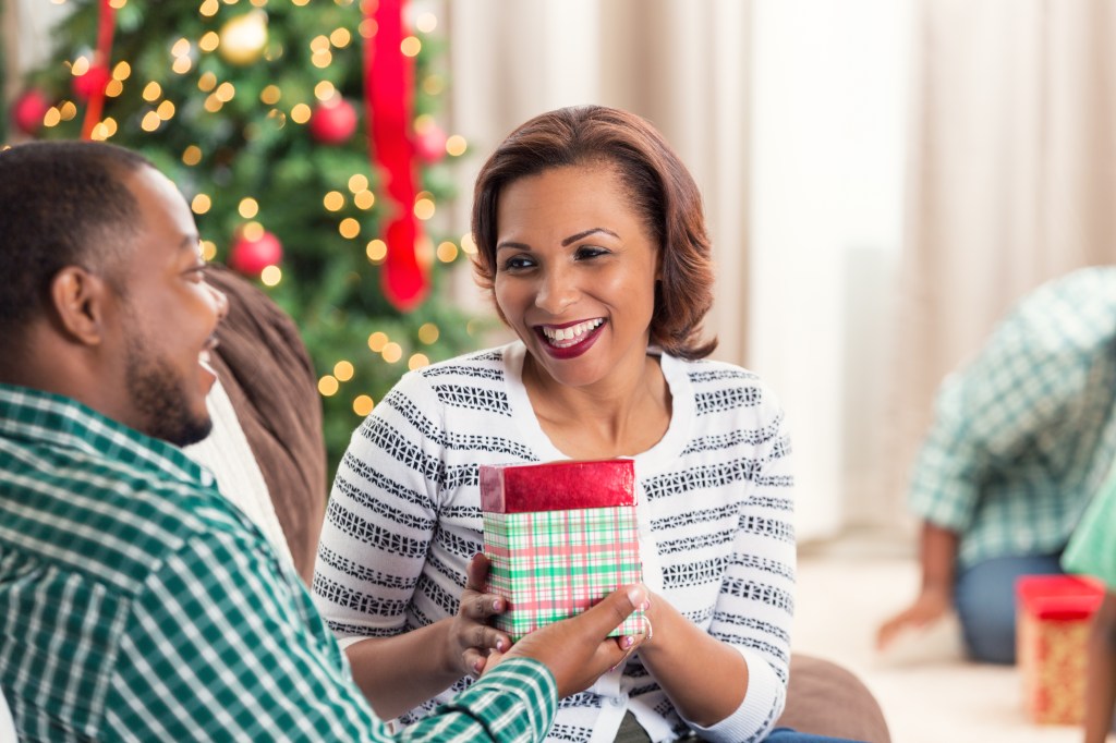 African American couple opening gift on Christmas morning