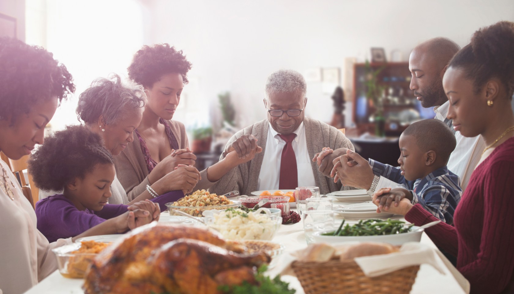 Family saying grace at holiday table