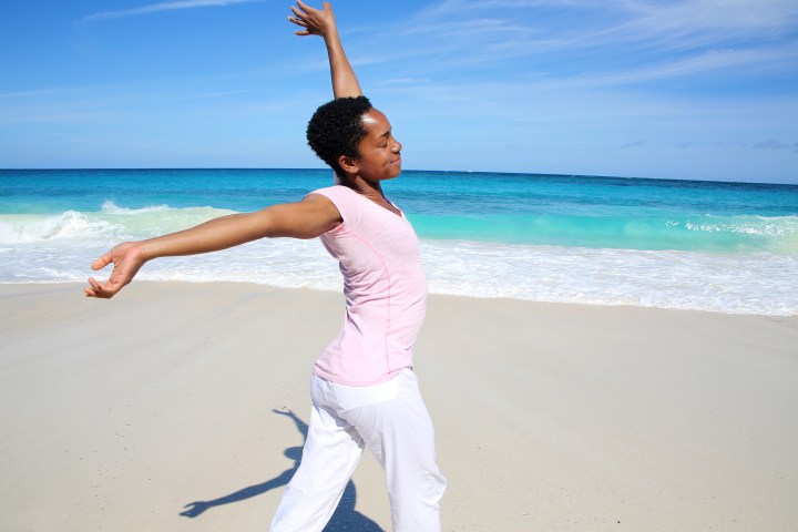Cheerful Woman stretching at the Beach