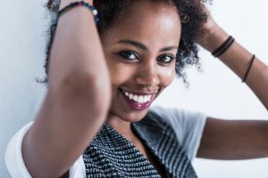 Portrait of smiling young woman with hands in her hair